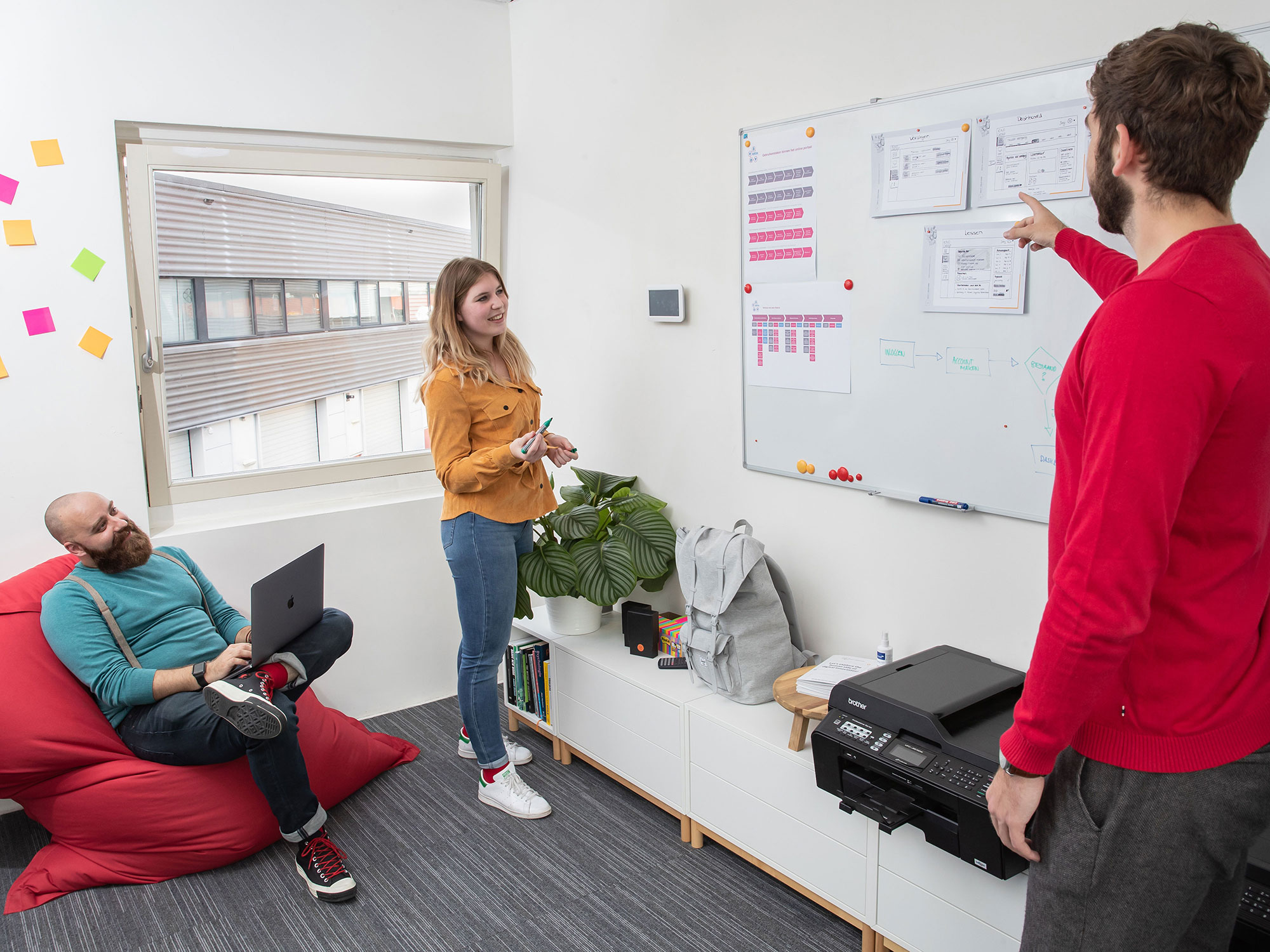 Designers bespreken schetsen bij whiteboard